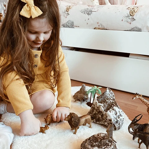 A young child creating a scene with animal figures