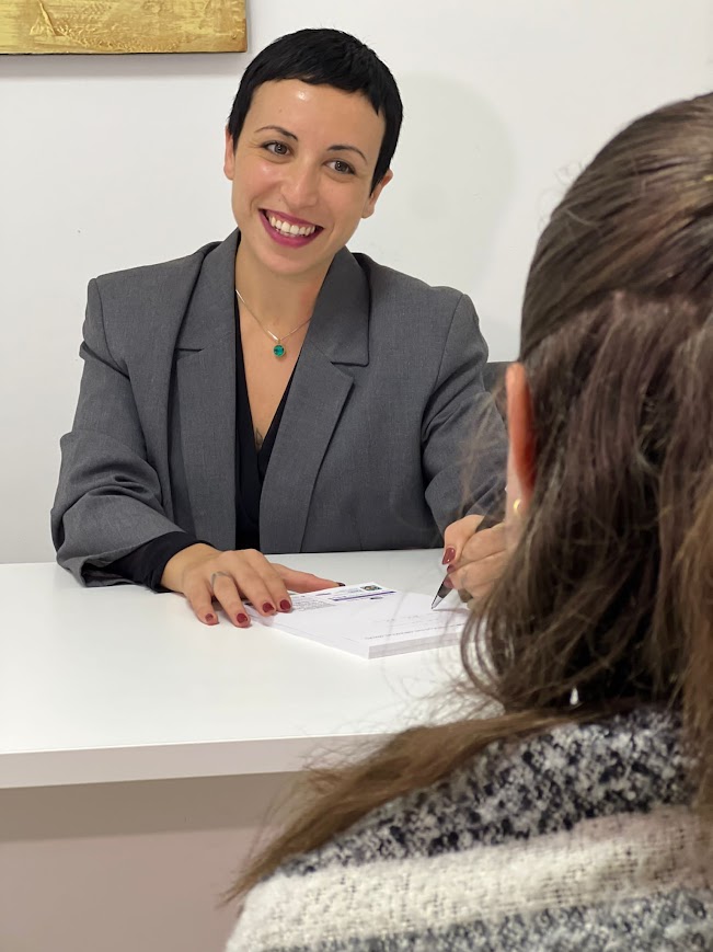 Katya smiling while sitting with a client across a table