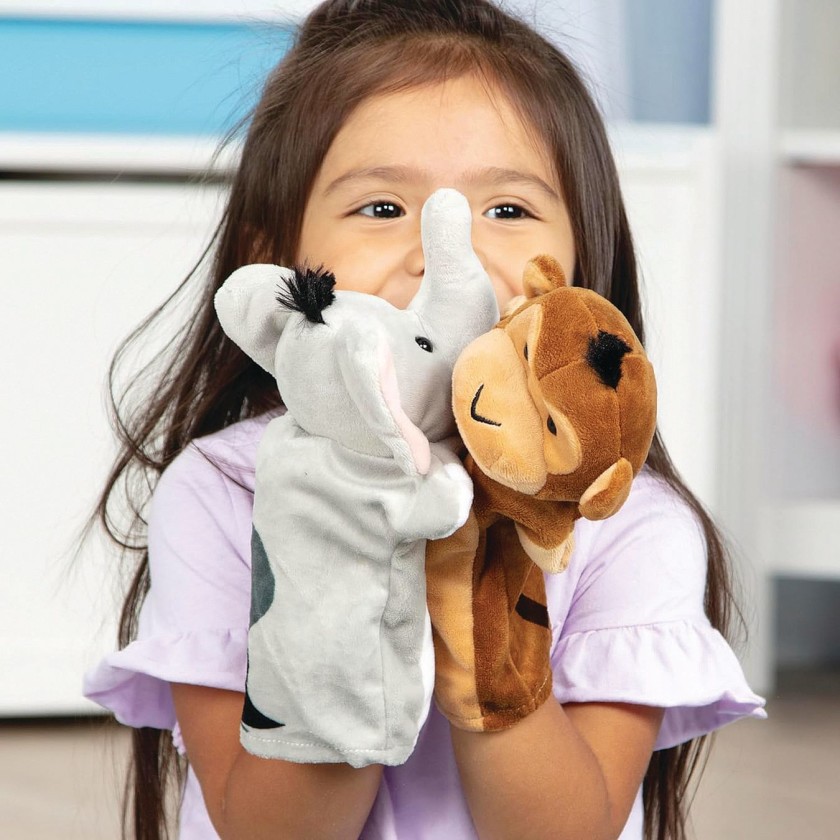 A young child holding elephant and lion animal puppets
