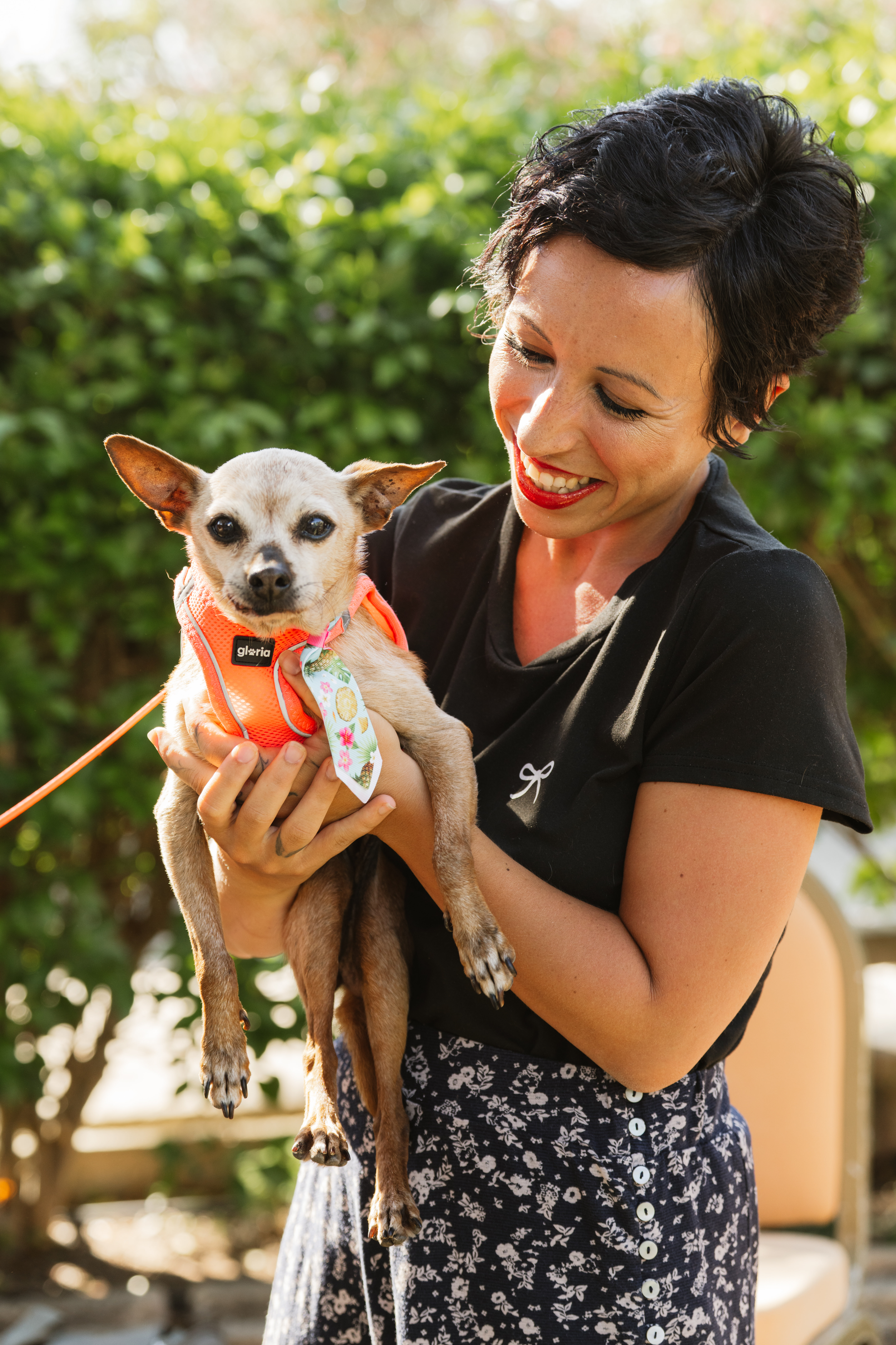 Katya smiling while holding her dog outdoors